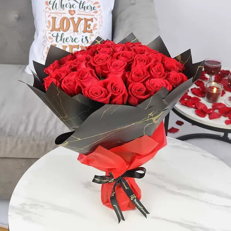 Bouquet of red roses on a table with black wrapping papers