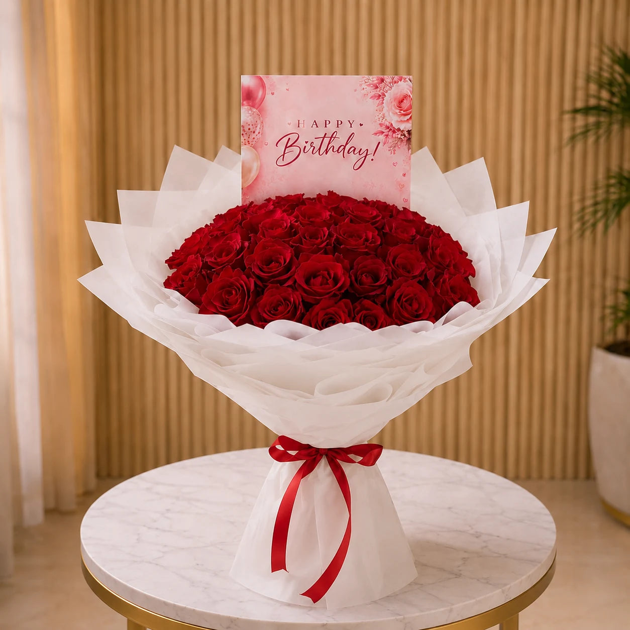 Bouquet of red roses with a birthday card on a round table.