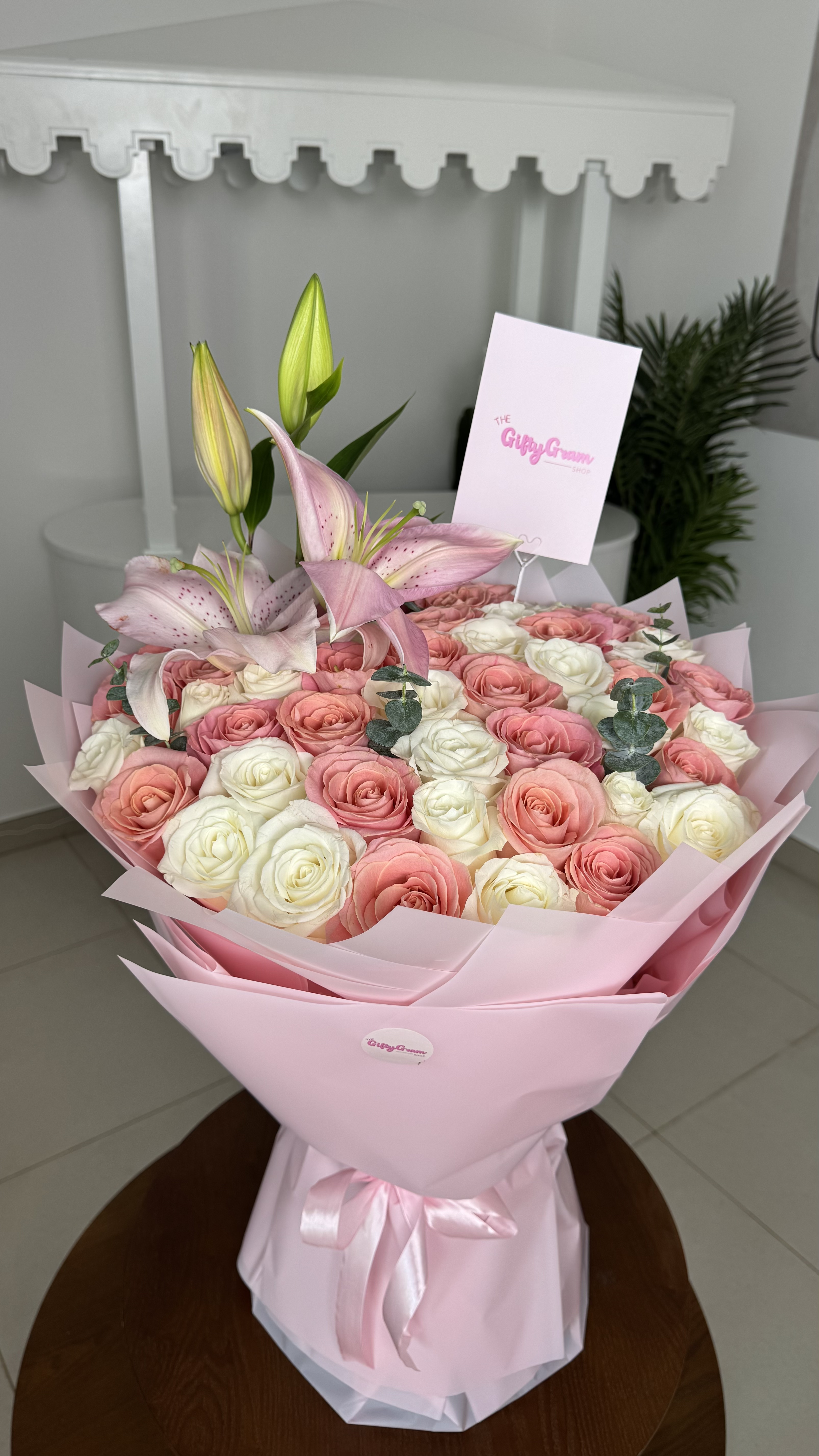 Bouquet of pink and white flowers with a card