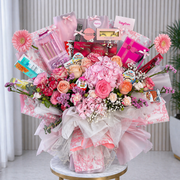 VIP Makeup Bouquets of pink flowers with various gifts and products on a marble table.